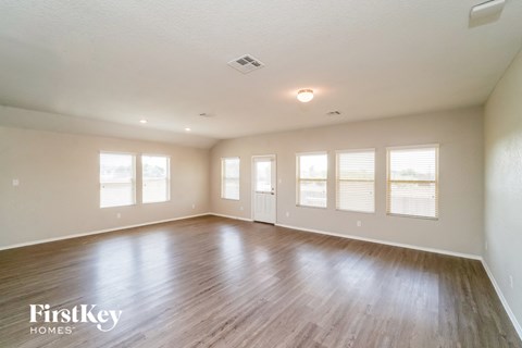 A spacious room with wooden floors and white walls.