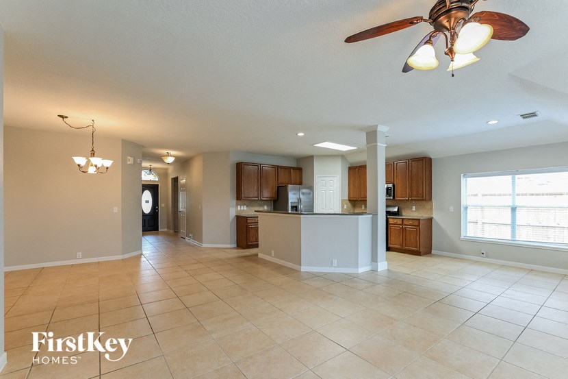 an empty kitchen and living room with a ceiling fan