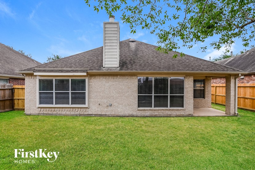 a brick house with a yard and a wood fence