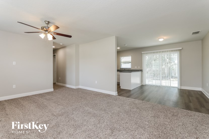 A spacious room with a ceiling fan and lighting fixtures.