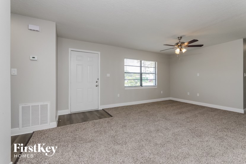 A spacious room with a ceiling fan and a window.