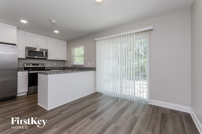 A kitchen with a refrigerator, microwave, and oven.
