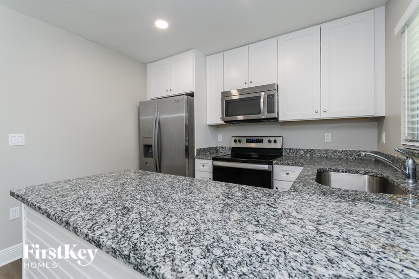 A kitchen with granite countertops and stainless steel appliances.