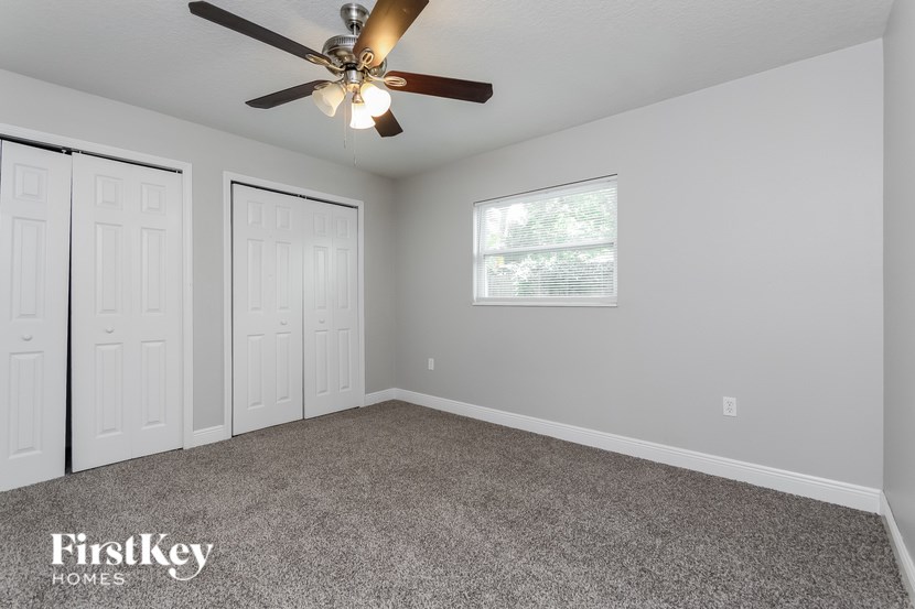 A room with a ceiling fan and two doors.