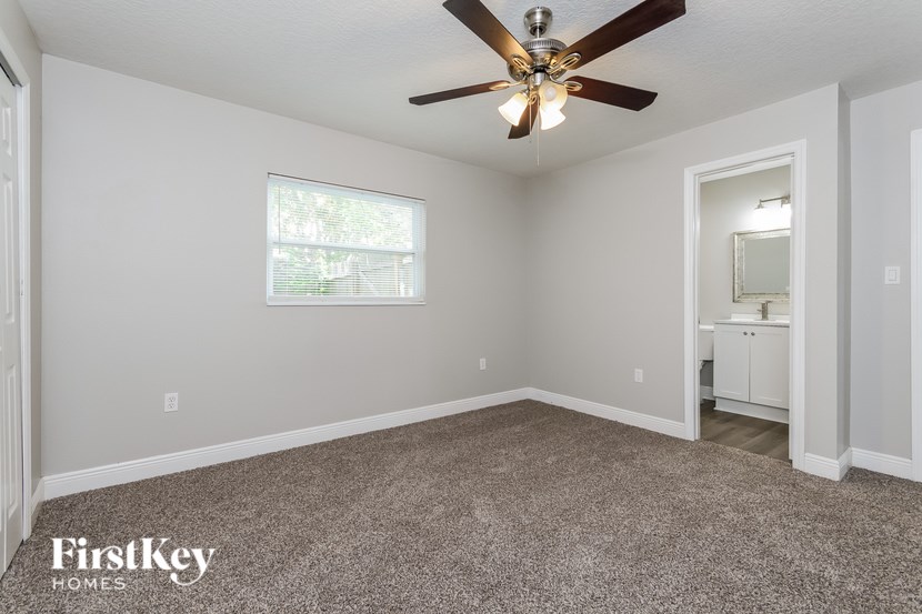 A room with a ceiling fan and a window.
