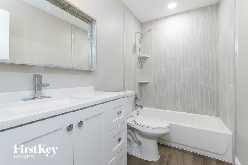 A white bathroom with a tub, sink, and toilet.