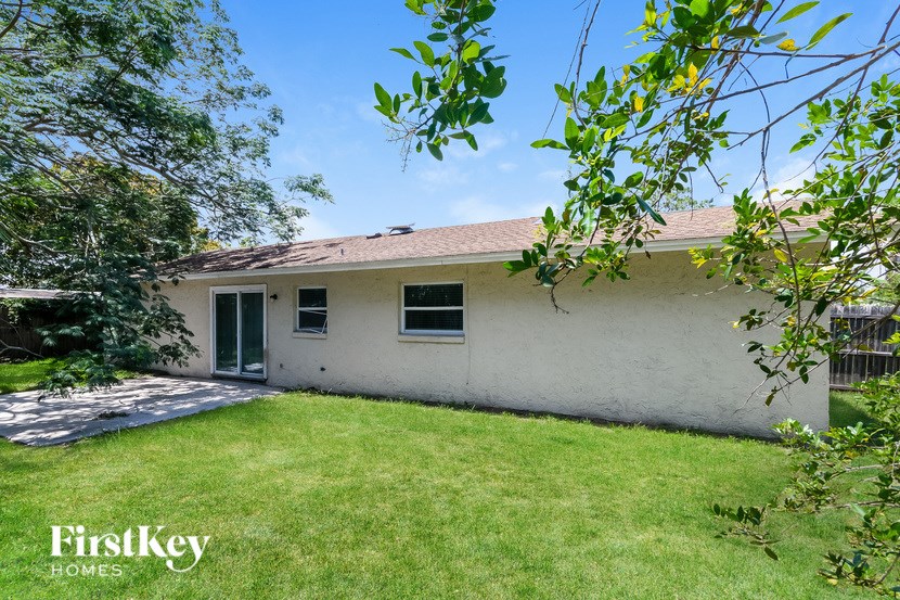 A white house with a green lawn in front of it.