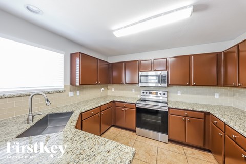 A kitchen with brown cabinets and a stainless steel oven.