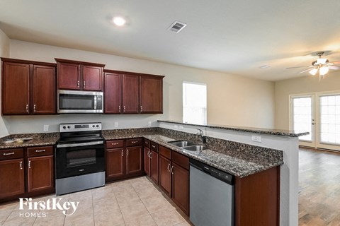A kitchen with brown cabinets and a black stove top oven.