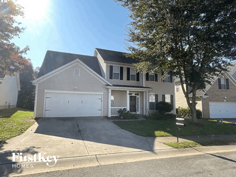 a white house with a driveway and a white garage door