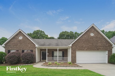 a brick house with a porch and a white garage door