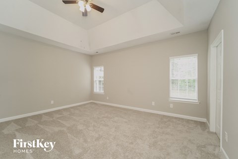 a bedroom with carpet and a ceiling fan