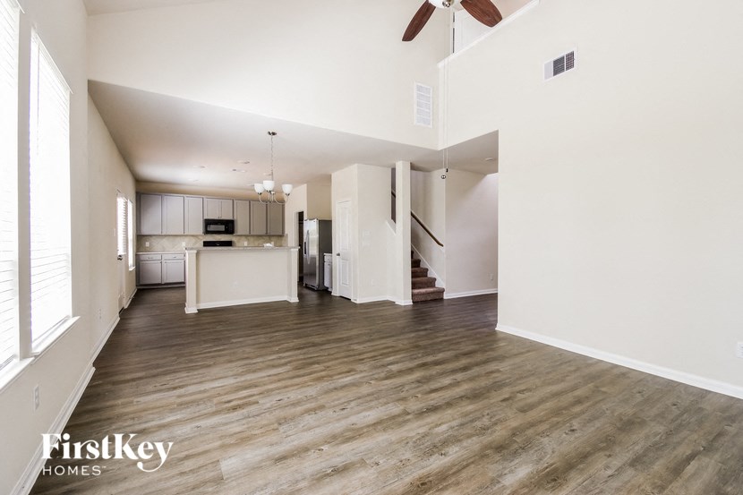 an empty living room and kitchen with wood floors