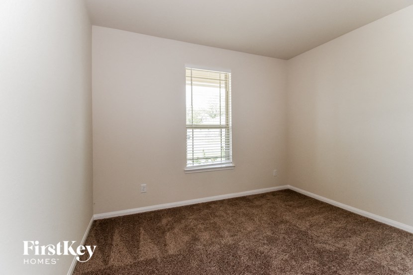 the living room of a home with carpet and a window