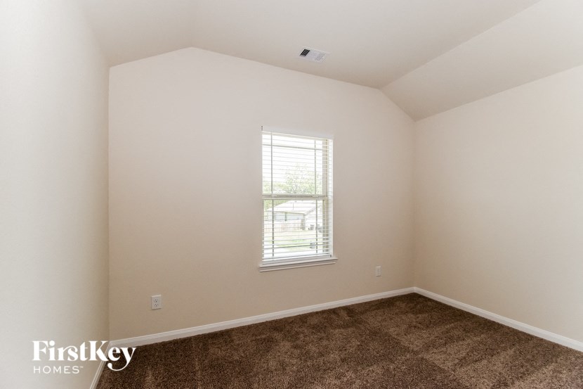the living room of a home with carpet and a window