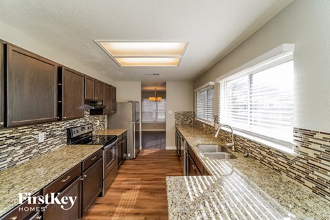 A kitchen with granite countertops and wooden cabinets.