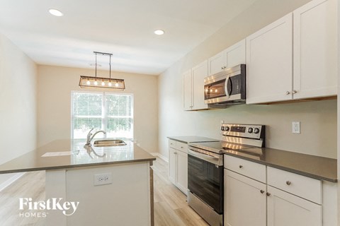 A kitchen with a stove top oven and microwave on the counter.