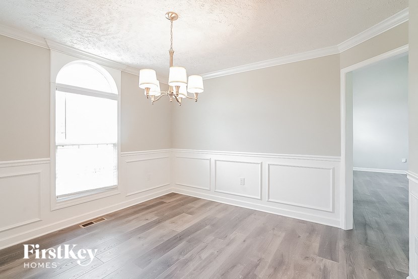 an empty room with a chandelier and a window