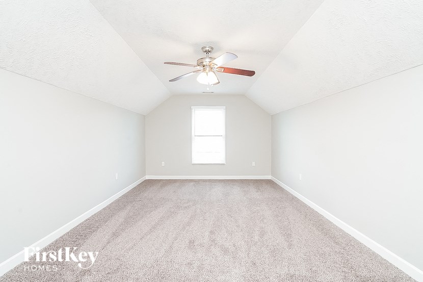 an empty room with a ceiling fan and a window