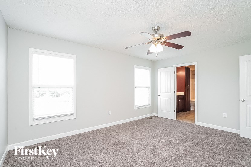 an empty living room with a ceiling fan