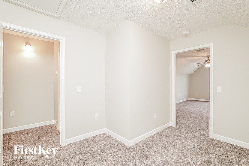 a bedroom with a carpeted floor and a door to a closet