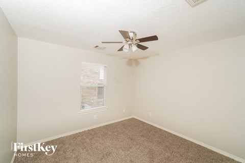 a bedroom with carpet and a ceiling fan