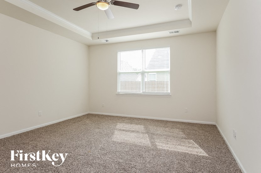 a empty room with a ceiling fan and a window