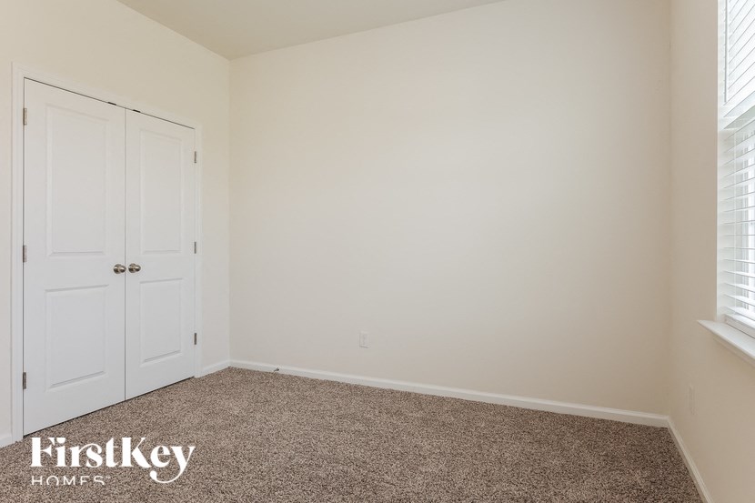 a bedroom with a carpeted floor and two white doors