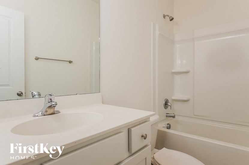 a bathroom with a sink and a tub and a mirror