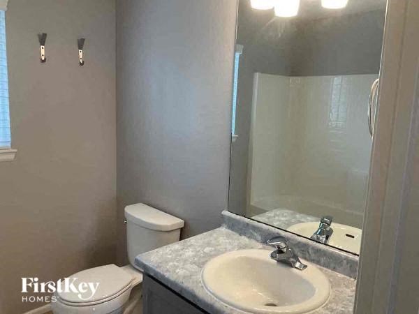 a bathroom with a toilet and a sink and a mirror