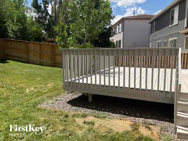 a wooden deck in the middle of a backyard