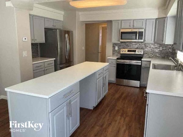 a kitchen with stainless steel appliances and white counter tops