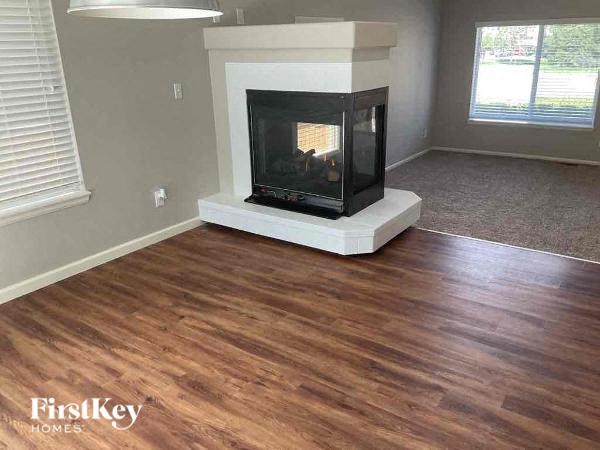 a living room with a fireplace and wooden floors