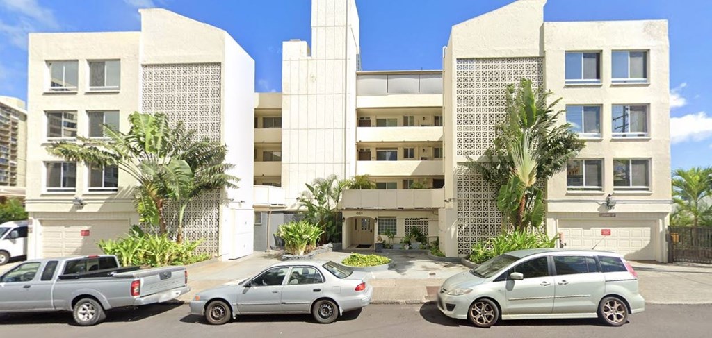 an apartment building with cars parked in front of it
