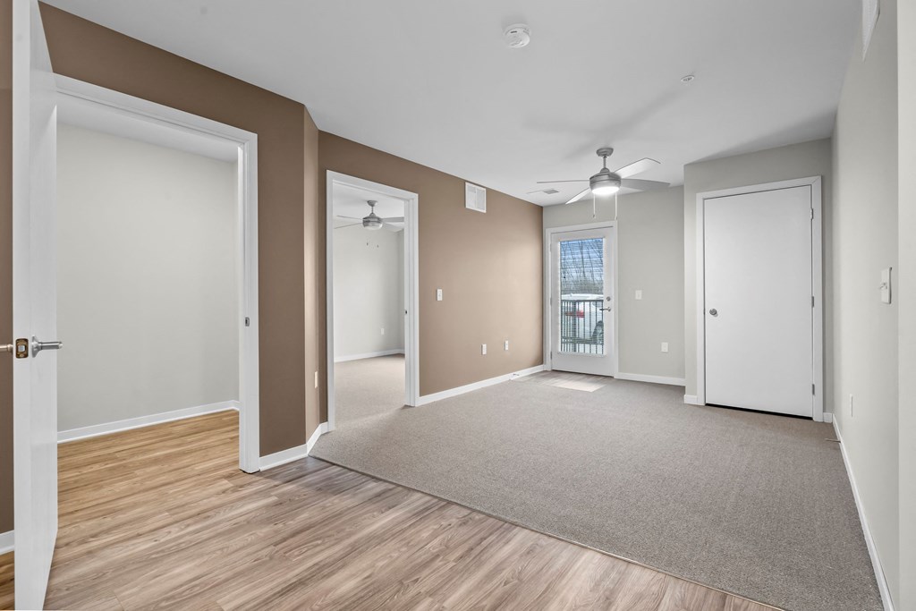the living room and dining room of a new home with wood flooring and white