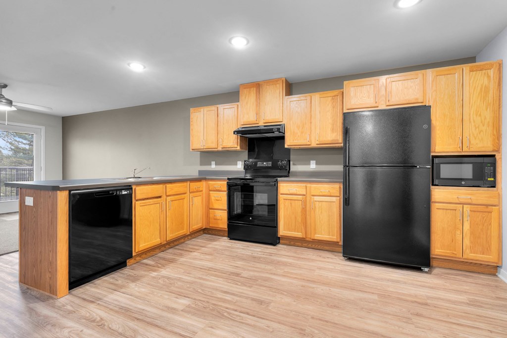 a kitchen with black appliances and wooden cabinets