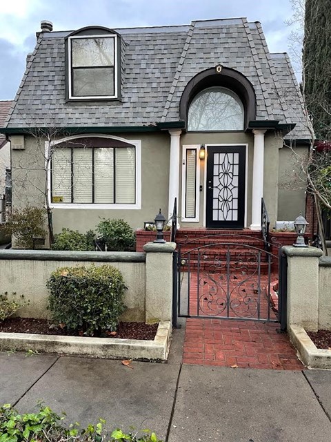 A house with a grey roof and a black gate.