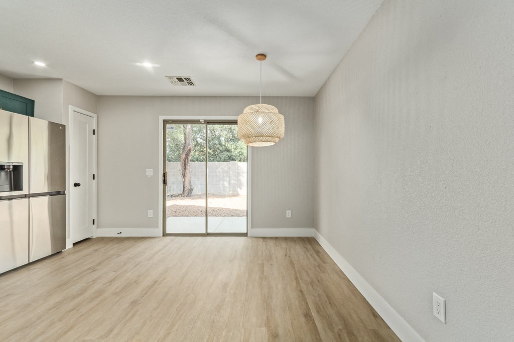 A room with a sliding glass door leading to a backyard.