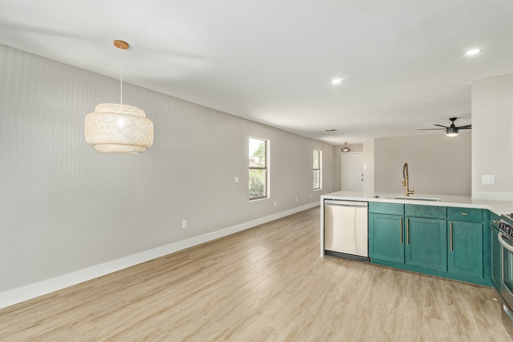 A kitchen with a white ceiling and a wooden floor.