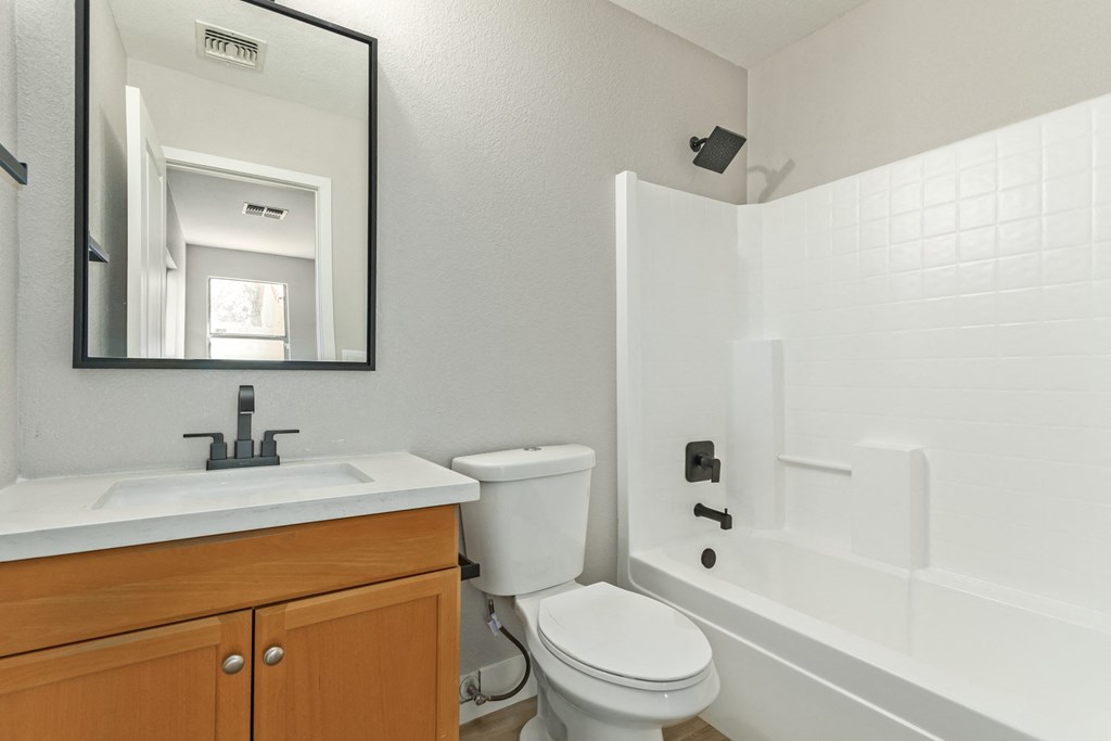 A white bathroom with a toilet, sink, and bathtub.