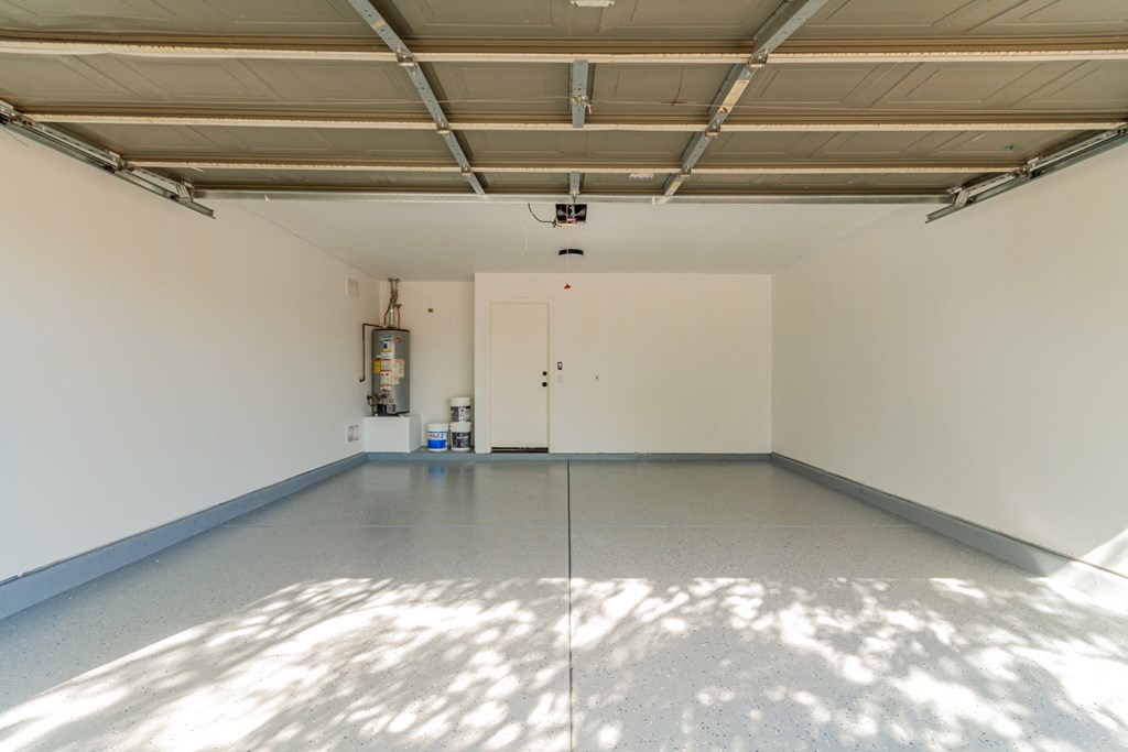 A large, empty room with a white door and a white wall.