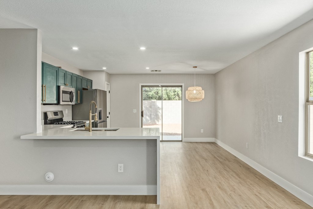 A modern kitchen with a bar counter and a window.