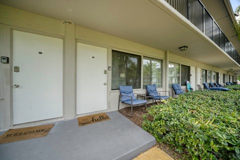 a porch with rocking chairs and closed doors