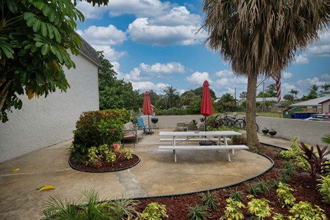 a patio with tables and umbrellas in front of a building