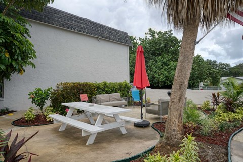a picnic table and chairs outside of a house