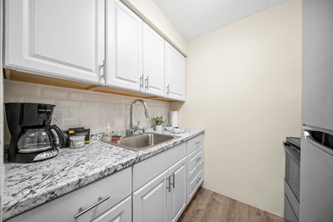 a kitchen with white cabinets and a sink