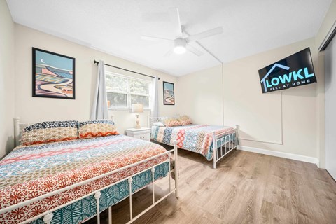 a bedroom with two beds and a ceiling fan