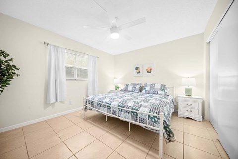 a bedroom with a bed and a ceiling fan