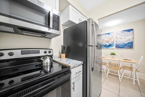 a kitchen with stainless steel appliances and a table and chairs