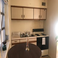 a kitchen with a table and a stove and a sink